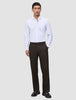 A man wears a white button-down shirt with a relaxed fit, Motion Suit Pants Relaxed Cognac, and dark loafers.