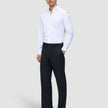 A man wearing a white button-down shirt and Motion Suit Pants Relaxed Midnight Blue, paired with dark brown loafers.