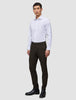 A man wearing a white dress shirt, Motion Suit Pants Slim Cognac, and black leather boots.