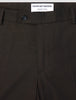 Close-up of Motion Suit Pants Slim Cognac in lightweight, breathable brown fabric, featuring a dark button and a brand label at the waistband.