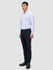 A man stands wearing a white button-down shirt and Midnight Blue Motion Suit Pants Slim made of breathable fabric.