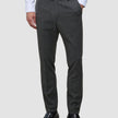 A man wearing a white dress shirt, Motion Suit Pants Slim Pepper Grey, and black loafers.