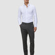 A man wearing a white button-down shirt, Motion Suit Pants Slim Pepper Grey, and black loafers.