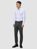 A man wearing a white button-down shirt, Motion Suit Pants Slim Pepper Grey, and black dress shoes.