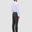 A man viewed from the back wearing a white button-down shirt and Motion Suit Pants Slim Pepper Grey with 360° stretch.
