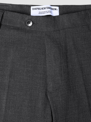 Close-up of the waistband and top of dark grey Motion Suit Pants Slim Pepper Grey, featuring a single button closure, 360° stretch slim-fit, and an interior brand label reading Shaping New Tomorrow.