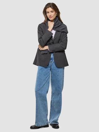A woman wearing a Women Nara Blazer Cool Brown, matching scarf, light pink shirt, and blue wide-leg jeans.