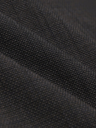 Close-up of a folded Women Nara Blazer Cool Brown made from dark, textured fabric.