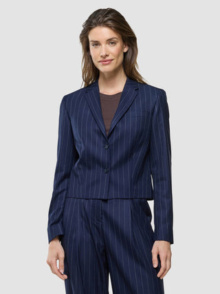 A woman wearing a Women Raina Short Blazer Night Sky Pinstripe over a brown top.