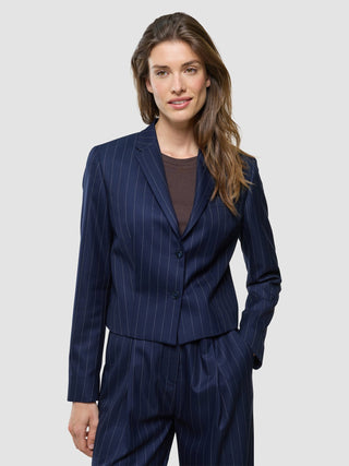A woman wearing a Women Raina Short Blazer Night Sky Pinstripe over a brown top.