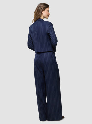 A woman wearing a Women Raina Short Blazer Night Sky Pinstripe and matching wide-leg trousers, seen from behind.