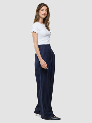 A woman wearing a white t-shirt and Women Raina Pants Wide Night Sky Pinstripe.