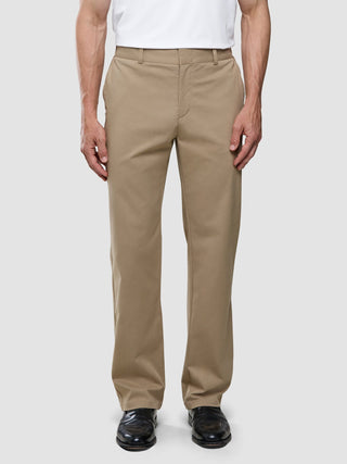 A person wearing a white t-shirt and Refine Cotton Pants Relaxed Fit Sand.