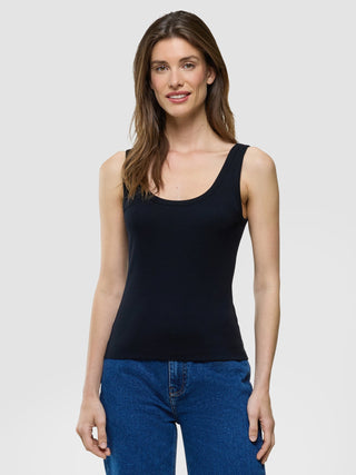 A woman wearing a Rib Tank Top Black and blue jeans.