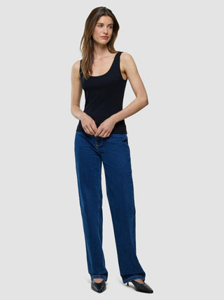 A woman wearing a Rib Tank Top Black and dark blue straight-leg jeans.