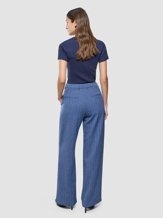 A woman seen from behind wearing a dark blue t-shirt and Women Serene Pants Wide Ombre Blue Herringbone.