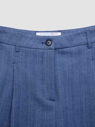 A close-up of Women Serene Pants Wide Ombre Blue Herringbone featuring a button closure and a Shaping New Tomorrow brand label on the waistband.