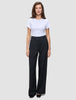 A person wearing a white t-shirt and black Serene Pants Wide Black, featuring a high-waisted, wide-leg Scandinavian design.