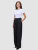 A smiling woman wears a white t-shirt tucked into high-waist, black Serene Pants Wide Black.