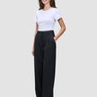 A smiling woman wears a white t-shirt tucked into high-waist, black Serene Pants Wide Black.