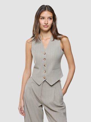 A woman wearing a Women Serene Short Vest Burnt Sugar Herringbone and matching trousers.