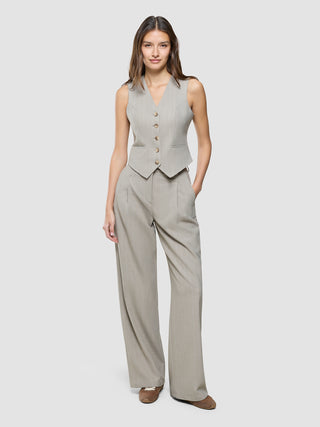 A woman wearing a Women Serene Short Vest Burnt Sugar Herringbone and matching wide-leg trousers.