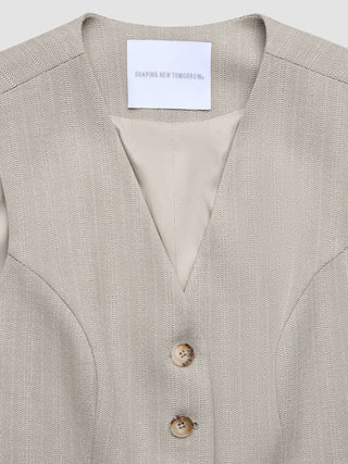 Close-up of a Women Serene Short Vest Burnt Sugar Herringbone with a Shaping New Tomorrow brand label.