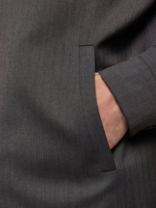 Close-up of a hand placed in the pocket of a Siena Jacket Herringbone Dark Brown.