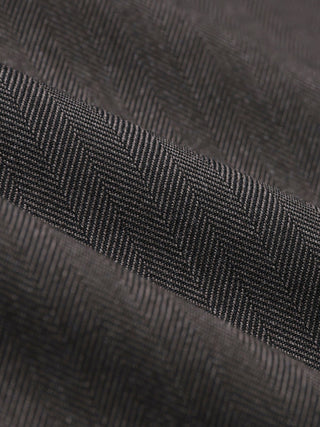 Close-up view of the Siena Jacket Herringbone Dark Brown fabric with a herringbone weave pattern.