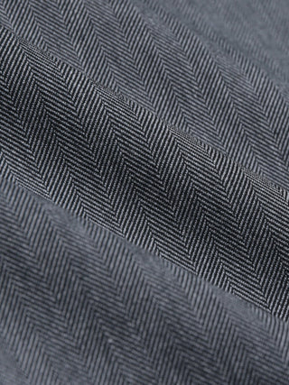 A close-up view of the dark grey herringbone fabric of the Siena Pants Relaxed Fit Herringbone Grey.