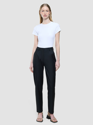 A woman wearing a white short-sleeved t-shirt tucked into Women Skye Pants Tapered Black.
