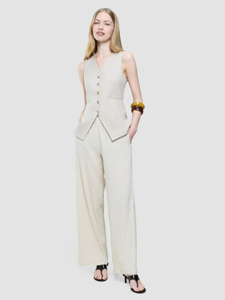 A woman wearing a Women’s Skye Long Vest Sandy Beige Melange and matching wide-leg trousers.
