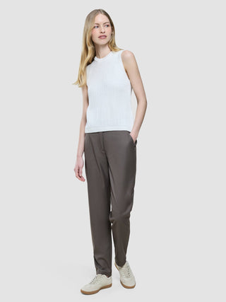A woman wearing a Women’s Structured Knit Top Off White, dark trousers, and sneakers.