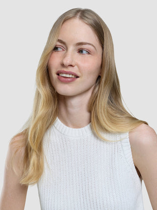 A woman with long blonde hair wearing a Women’s Structured Knit Top Off White looks away from the camera.
