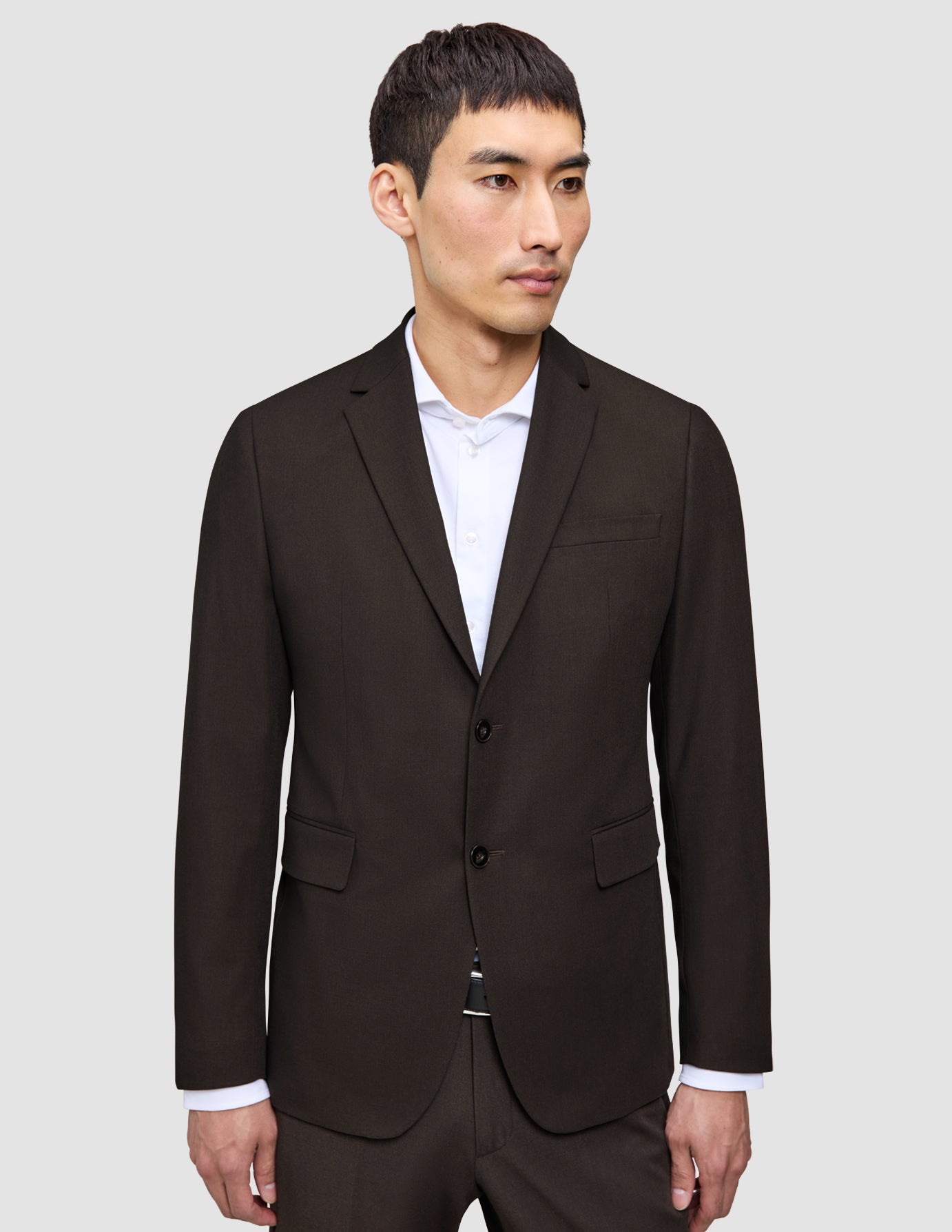 A man wearing The suit that does it all Motion Suit jacket over an elevated white collared shirt.