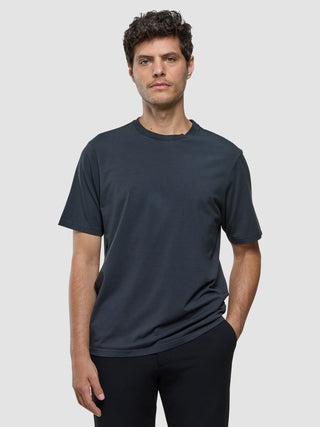 A man wearing a Supima T-shirt Box Fit Deep Grey with 360° stretch.