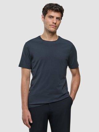 A man wearing a Supima T-shirt Deep Grey and black trousers with 360° stretch.