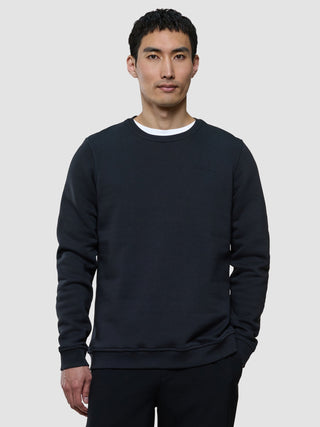 A man wearing a Sweat Crewneck Deep Grey over a white t-shirt.