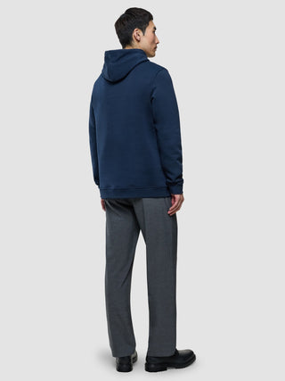 A man seen from behind wearing a Sweat Hoodie Dark Navy and grey trousers.
