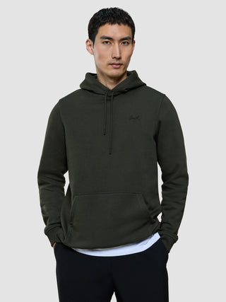 A man wears a dark green Sweat Hoodie Green Night with a small logo on the chest.