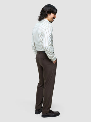 A man seen from behind wearing a white striped button-down shirt and Tech Wool Suit Pants Regular Cocoa Brown with his hands in his pockets.