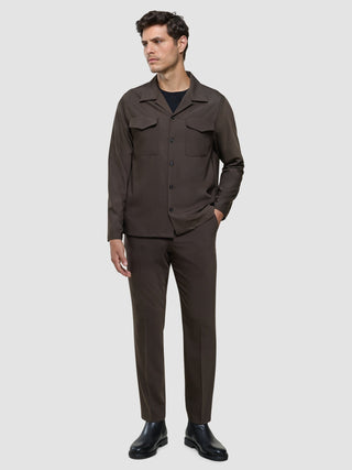 A man wears a Tech Wool Overshirt Cocoa Brown with front pockets and matching trousers.