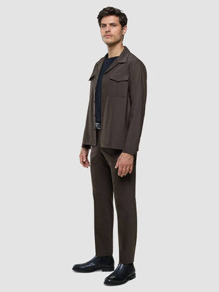 A man wearing a Tech Wool Overshirt Cocoa Brown over a dark t-shirt, matching brown trousers, and black boots.