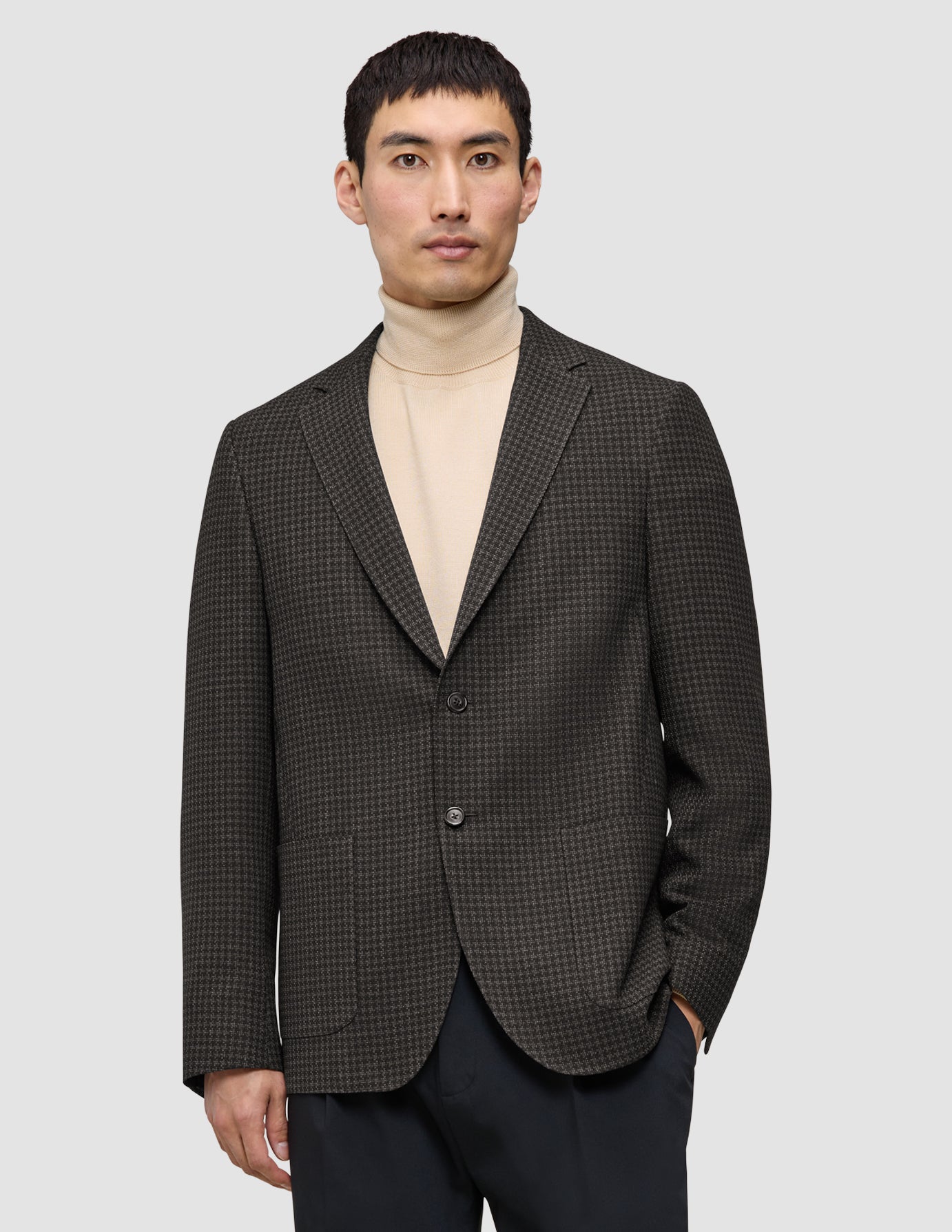 A person wearing a Timeless Wool Blazer Slim Dark Brown Check over a beige turtleneck.