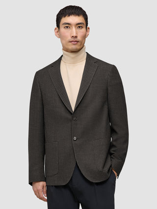 A person wearing a Timeless Wool Blazer Slim Dark Brown Check over a beige turtleneck.