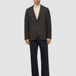 A person wearing a Timeless Wool Blazer Slim Dark Brown Check over a tan turtleneck and dark trousers.