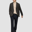 A person wears a Timeless Wool Blazer Slim Dark Brown Check over a tan turtleneck sweater, paired with black trousers and black loafers.