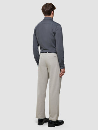 A man from behind wearing a Travel Shirt Charcoal Grey Regular, light tan trousers, and black loafers.