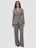A model wearing a grey herringbone bouclé blazer with a three-button closure and matching Women Ashryn Pants Wide Domino Herringbone.