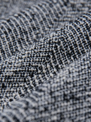 Close-up of the black and white textured herringbone bouclé weave on the Women Ashryn Pants Wide Domino Herringbone.
